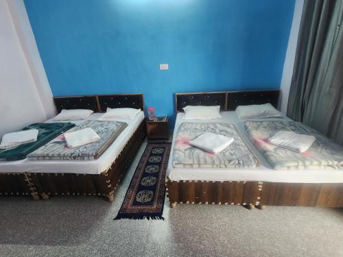 two beds sitting next to each other in a room at Hotel Namami Gange & Restaurant in Kedārnāth