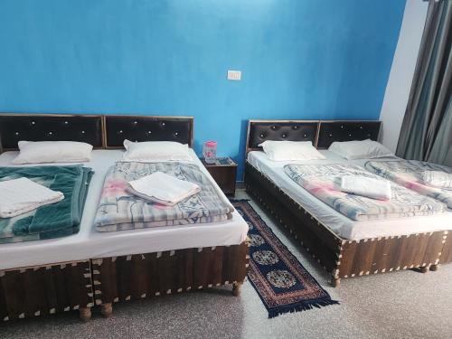 two beds sitting next to each other in a room at Hotel Namami Gange & Restaurant in Kedārnāth