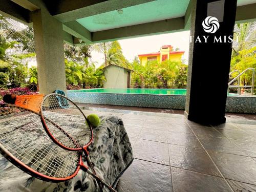 a tennis racket and tennis ball sitting on a bench at Ocean Olive Villa by Staymist in Nagaon