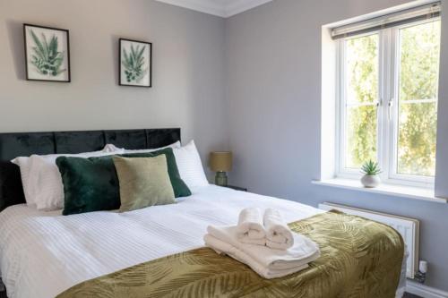 a bedroom with a bed with towels on it at The Rainbow Retreat by Sheppey Stays in Iwade