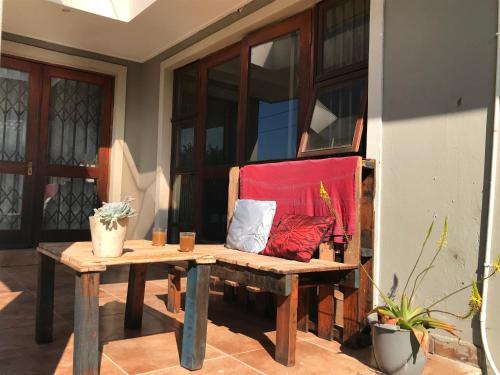 VosburgにあるCozy Luxury NO ANIMAL PRODUCTS ALLOWED ON PREMISESの赤い毛布が掛けられたポーチに置かれたベンチ