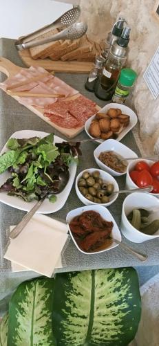 a table topped with plates of food and vegetables at Il Daviduccio Suite in Siracusa