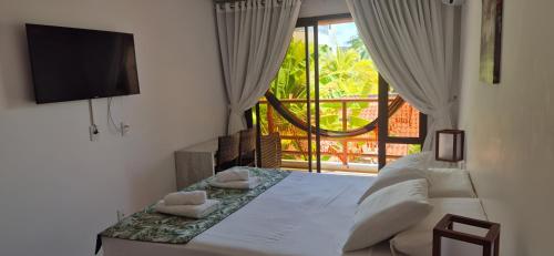 a bedroom with a bed with a tv and a window at Varandas do Mar pé na areia in Cumbuco