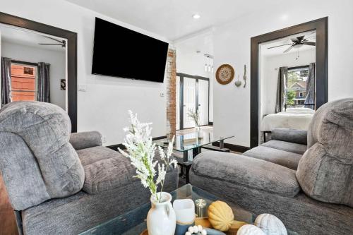 a living room with two couches and a flat screen tv at Cozy 4BR Home in Heart of Niagara Falls in Niagara Falls