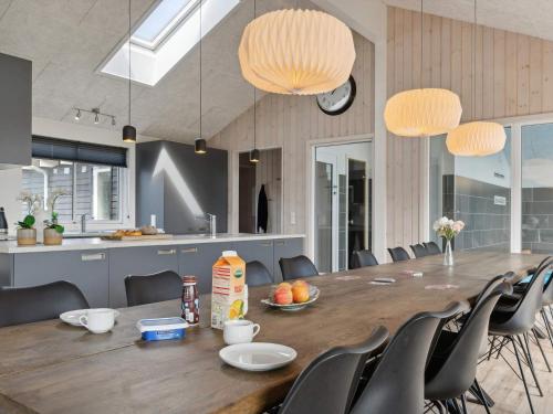 a large wooden table with chairs and a kitchen at Luxury Retreat in albaek - By Traum Ferienwohnungen in Ålbæk