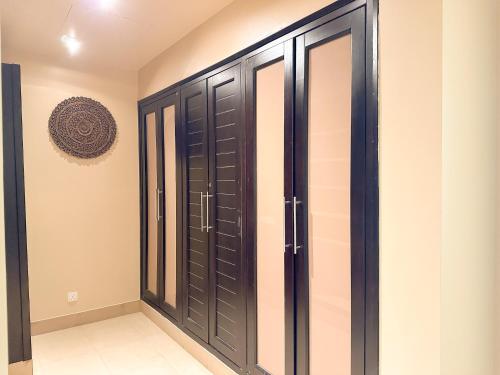 a wardrobe with black doors in a room at 2 Bedroom Villa with Private Pool in Ras al Khaimah