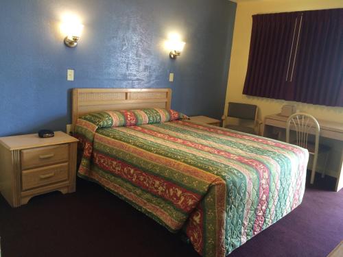 a hotel room with a bed and a night stand at Blarney Inn in Shamrock
