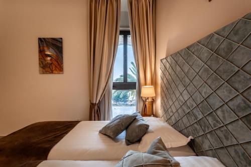 a bedroom with a bed with a headboard and a window at Notre Dame of Jerusalem Center in Jerusalem