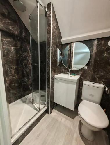 a bathroom with a toilet and a glass shower at Apart Fosses 10 min to PAsterix Airport PARIS 30 min in Fosses