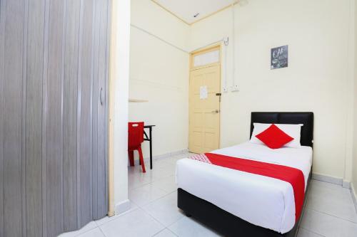 a bedroom with a bed and a red pillow at Hotel O Pelangi Marang in Marang
