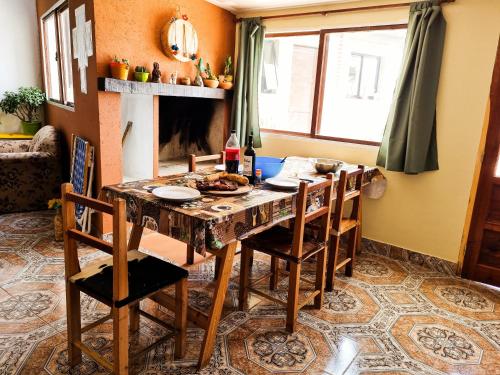 ein Esszimmer mit Tisch und Stühlen und einem Kamin in der Unterkunft Hospedaje Familiar Arcoíris Jujuy in San Salvador de Jujuy