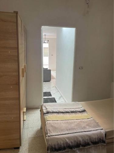 a room with two beds in a room with a doorway at House of la Marsa in Dar Tahar Zaouch