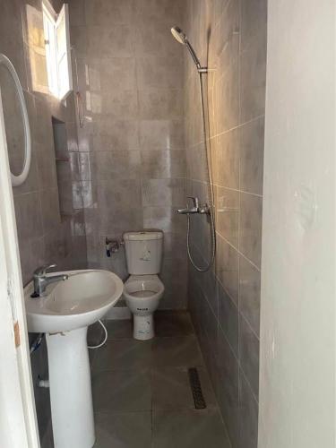 a bathroom with a toilet and a sink at House of la Marsa in Dar Tahar Zaouch
