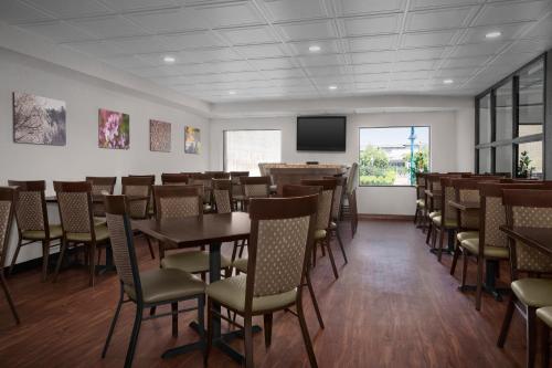 a dining room with tables and chairs and a flat screen tv at The Suites Hotel at Waterfront Plaza in Duluth