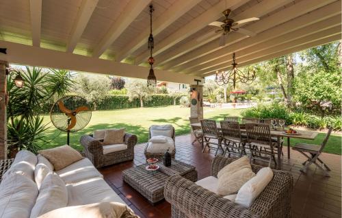 Un patio con un sofá blanco y sillas y una mesa. en Il Perle, en Padenghe sul Garda