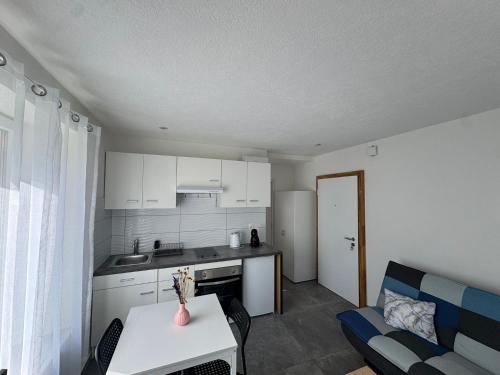 Una cocina y una sala de estar con una mesa y un sofá. en AA - Cosy, en Couvet