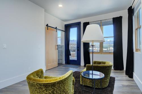 a living room with two chairs and a table at She Shes Downtown Salidas Sunny Overlook in Salida