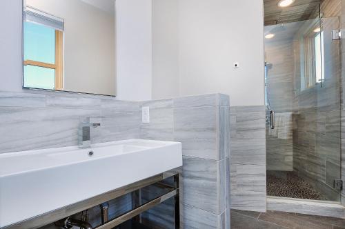 a bathroom with a white sink and a shower at She Shes Downtown Salidas Sunny Overlook in Salida