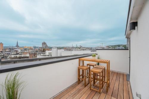a balcony with two chairs and a table on a roof at Superbe appartement 2 chambres en centre-ville in Liège