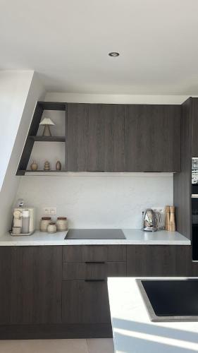 a kitchen with brown cabinets and a white counter top at Superbe appartement 2 chambres en centre-ville in Liège