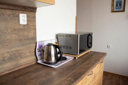 a kitchen counter with a microwave and a tea kettle at Vila Imagina in Ratboř