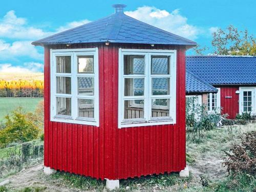 a red house with two windows in a yard at 4 person holiday home in VEBERÖD-By Traum in Veberöd