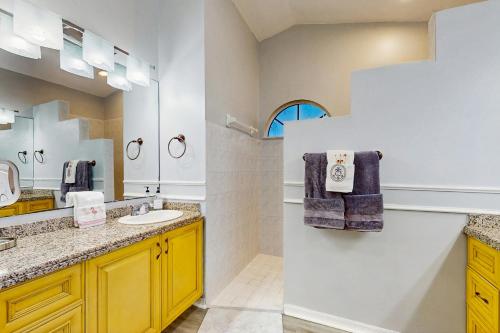 ein Badezimmer mit Waschbecken und Spiegel in der Unterkunft Coral Palm Villa in Cape Coral