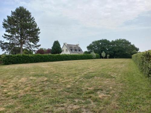 a large grassy field with a house in the background at Charming Breton house in Hénansal in Hénansal