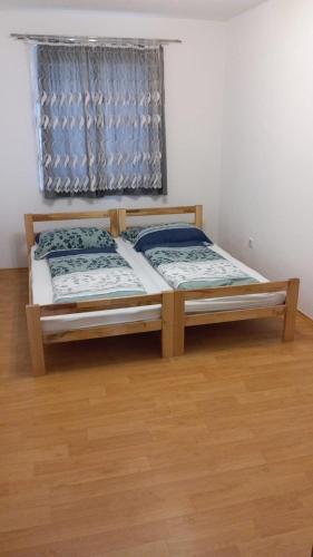 two beds in a room with a window at REAL apartment in Sarajevo