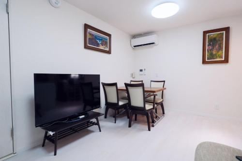a living room with a television and a table with chairs at Taito City Negishi 2Ldk-TT0323 in Tokyo