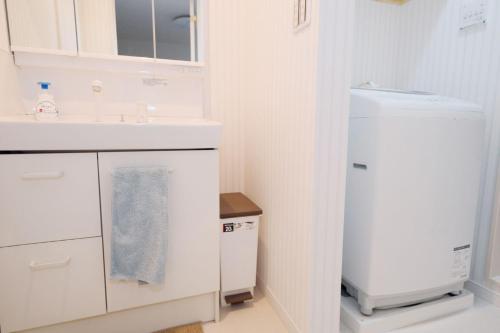 a white kitchen with a sink and a refrigerator at Taito City Negishi 2Ldk-TT0323 in Tokyo