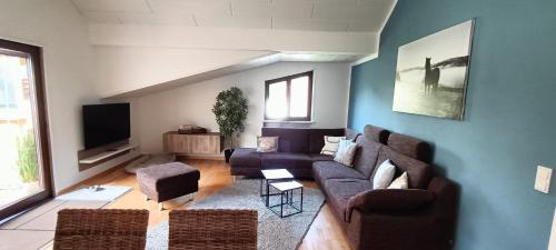 a living room with a couch and a tv at Ferienwohnung Terrassenzeit in Illingen
