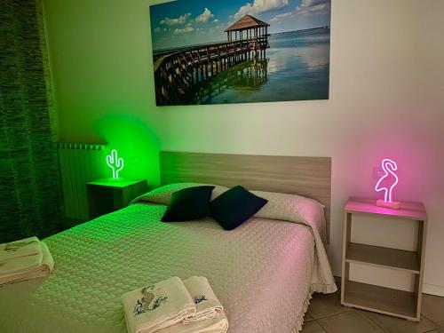 a bedroom with a bed with a neon sign on a table at A casa di Giulia in Rosolina