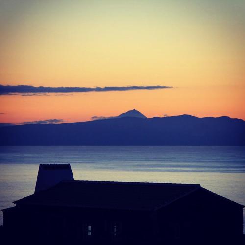 a sunset over the water with a mountain in the background at Pico da Vigia in Santa Bárbara