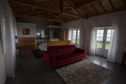 a living room with a red couch and a table at Pico da Vigia in Santa Bárbara