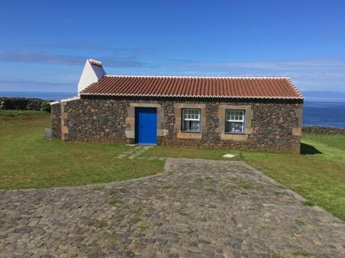 a stone house with a blue door on a hill at Pico da Vigia in Santa Bárbara