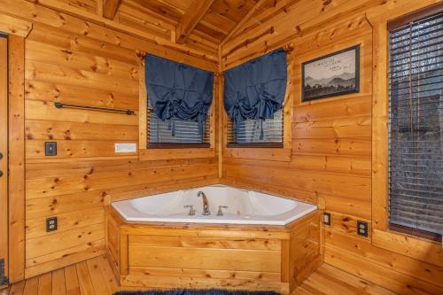 a bathroom with a tub in a wooden room at A Bear On The Ridge by American Patriot Getaways in Cartertown