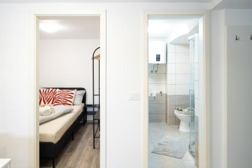 a bedroom with a bed and a bathroom with a toilet at THE LOFT Apartments in Ljubljana