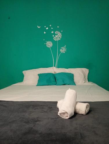 a bedroom with a bed with a green wall at MarJeri in Jericoacoara