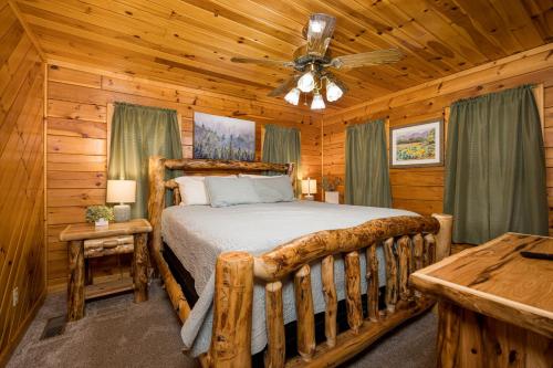 a bedroom with a bed in a log cabin at Absolutely Fabulous by American Patriot Getaways in Park Settlement
