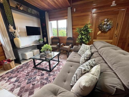a living room with a couch and a table at Casa de Temporada Vó Laura in Urubici