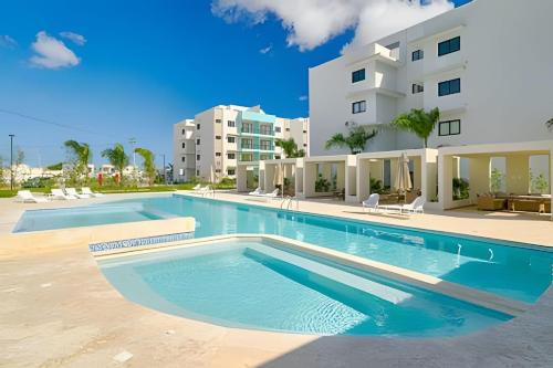 プンタ・カナにあるCozy 1Bdrm Apt. @ 10mins from Punta Cana beachesの建物の前の大きなプール