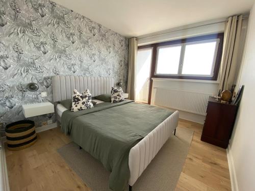 a bedroom with a bed in a room with a wall at Eiffel Tower View & Pool in Paris