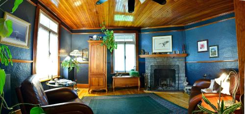 a living room with blue walls and a fireplace at Auberge À La Chouenne in La Malbaie