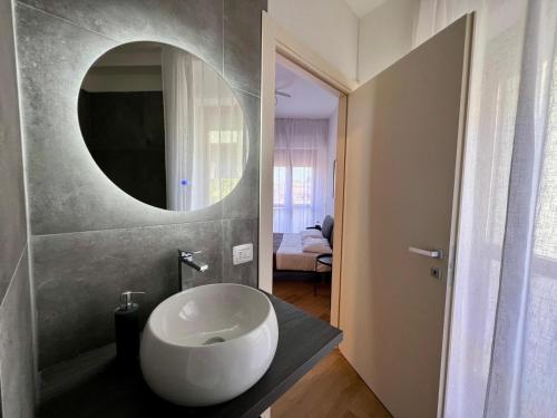 フォリーニョにあるFoligno City Roomsの白い洗面台と鏡のあるバスルーム