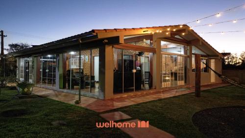 Una casa con puertas de vidrio y luces. en Chacara em Santa Barbara com Piscina, en Águas de Santa Bárbara