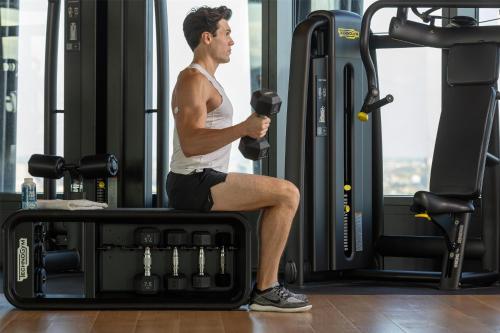 a man is sitting on a treadmill in a gym at art'otel London Hoxton in London