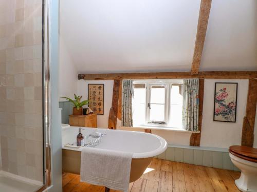 a bathroom with a bath tub and a toilet at Bank House in Norwich