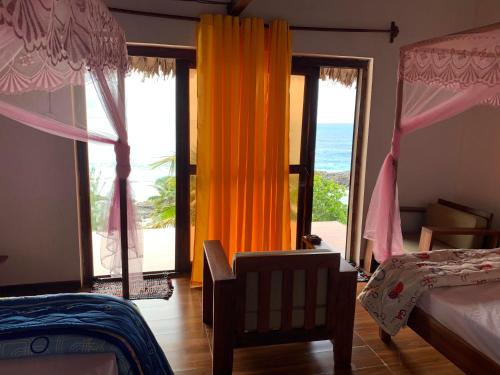 a bedroom with a bed and a view of the ocean at Nosy-Borah Holidays in Analabe
