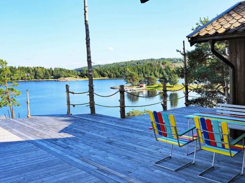 two chairs and a table on a deck with a view of a lake at 6 person holiday home in HENÅN in Sundsandvik